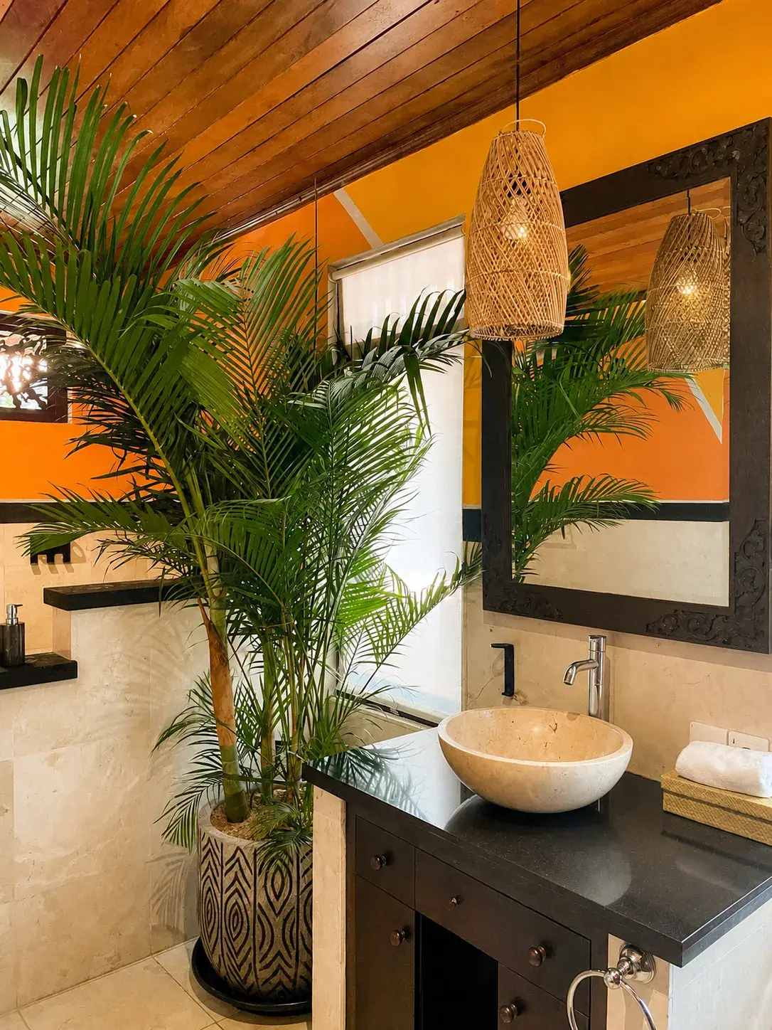 Stone sink and mirror against an orange wall